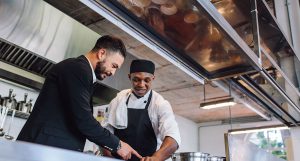 chef and manager in restaurant kitchen working