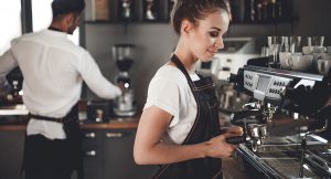 woman making coffee in a restaurant kitchen