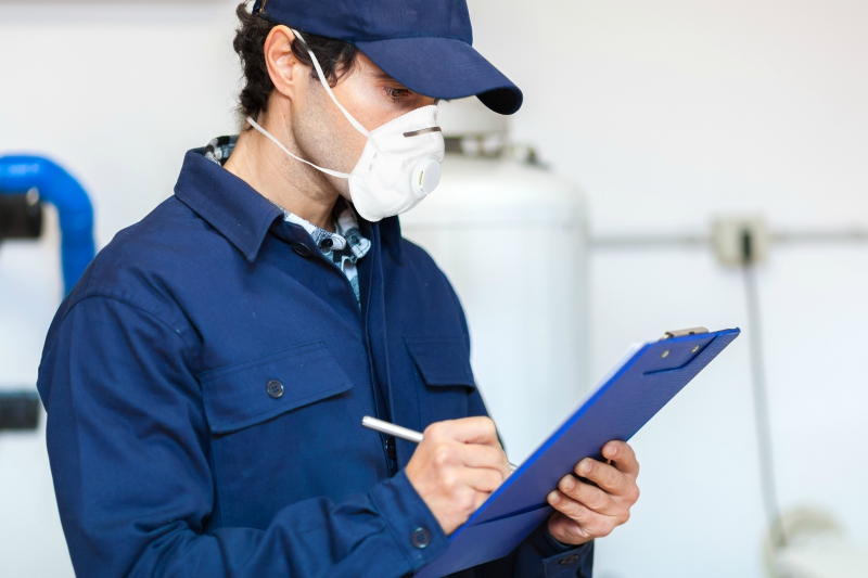 technician with clipboard wearing mask