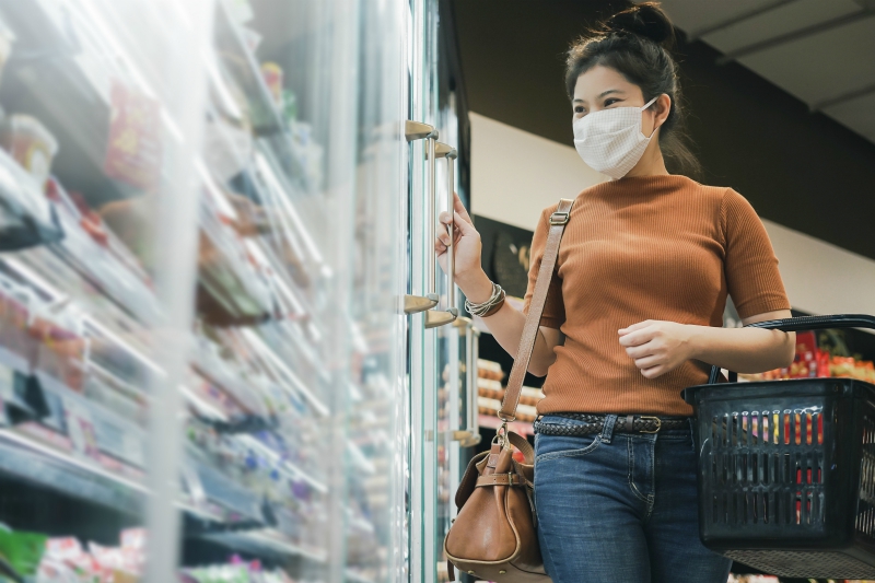 woman grocery shopping wearing mask