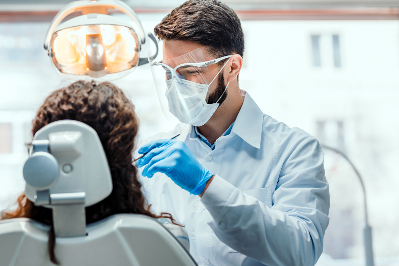 dentist cleaning patient's teeth