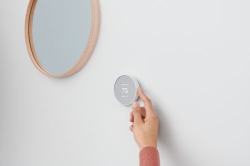 person using smart home device to adjust temperature in room