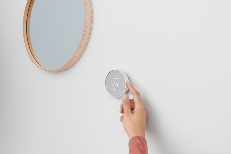 person adjusting temperature on smart home device
