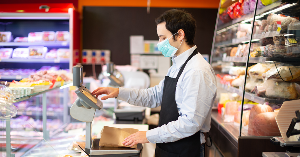 man wearing mask working at grocery store