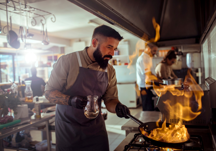 chef cooking on a stove with a fire