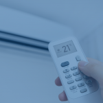 hand holding a remote and changing temperature on a ductless air conditioner