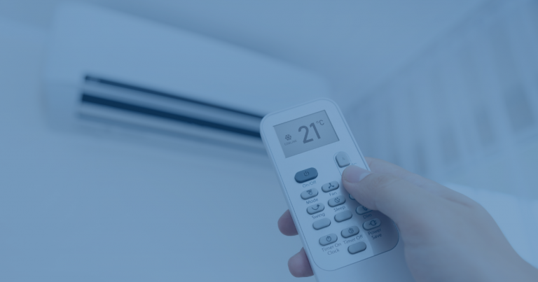 hand holding a remote and changing temperature on a ductless air conditioner