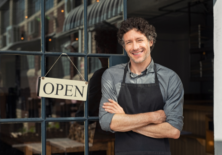 Restaurant owner standing in front of open sign